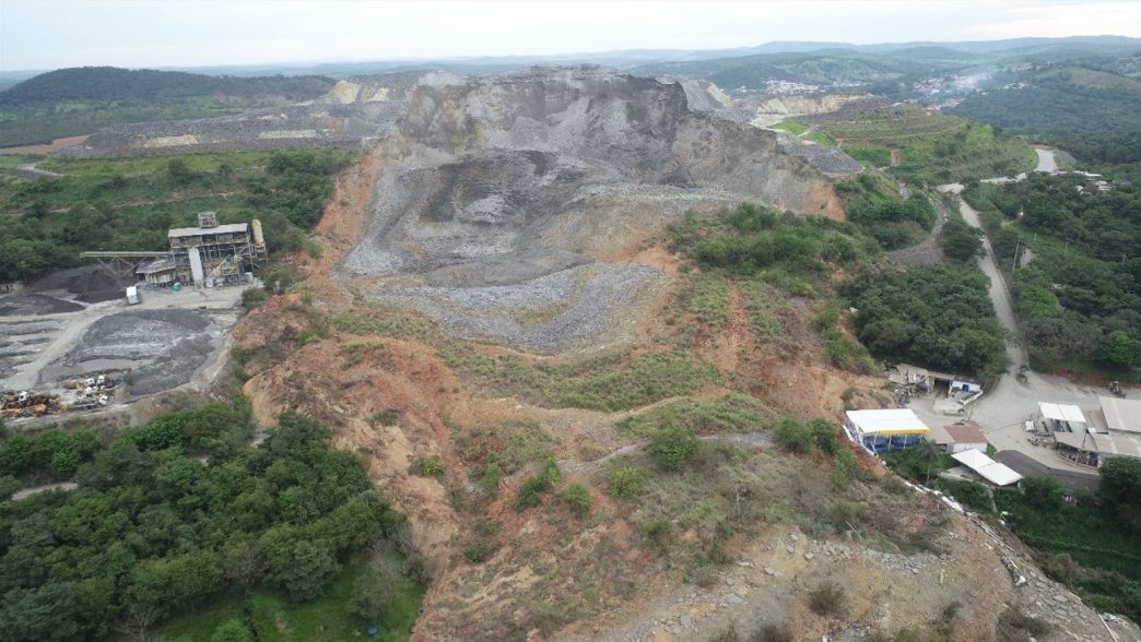 Vista aérea de pedreira ativa cercada por vegetação