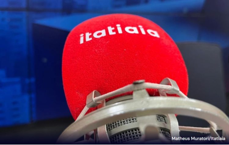 Microfone da rádio Itatiaia com espuma na cor vermelha e logomarca da rádio em destaque com letras brancas.