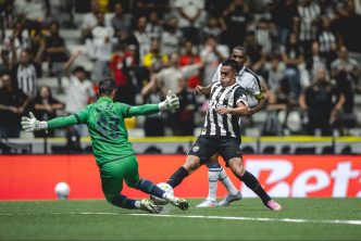 Atacante do Atlético finaliza dentro da área enquanto goleiro do Remo tenta a defesa em lance decisivo na Arena MRV pelo Campeonato Brasileiro, com torcida ao fundo.