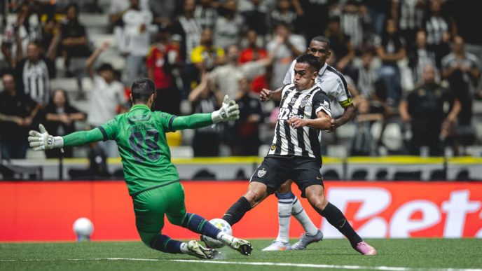 Atacante do Atlético finaliza dentro da área enquanto goleiro do Remo tenta a defesa em lance decisivo na Arena MRV pelo Campeonato Brasileiro, com torcida ao fundo.