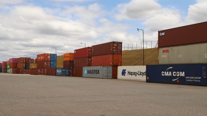 Pátio logístico com contêineres de exportação empilhados, simbolizando o crescimento do comércio exterior de Minas Gerais em 2026.