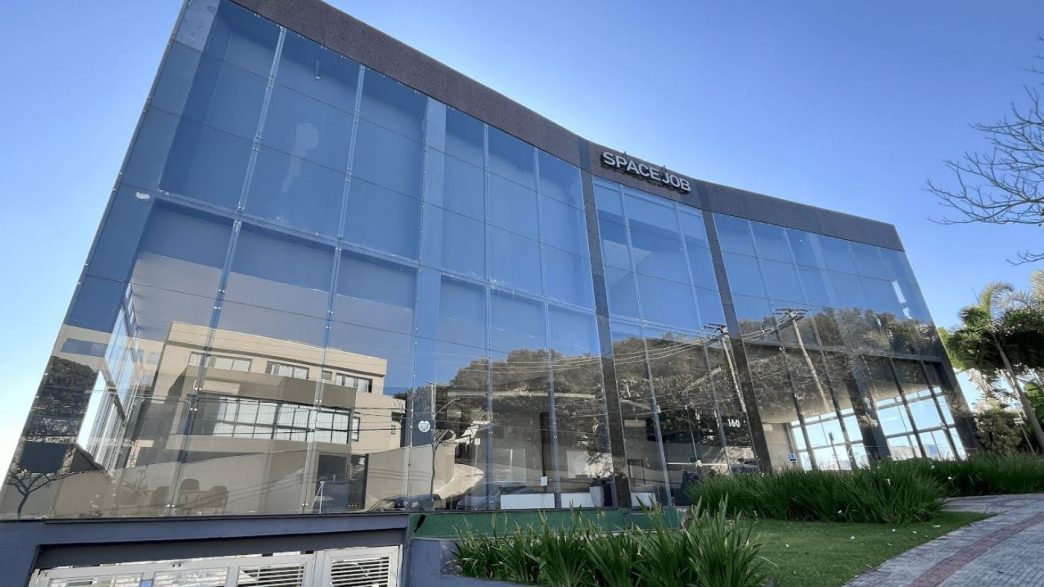 Fachada moderna do prédio Spacejob Coworking Prime, em Belo Horizonte, com estrutura de vidro e arquitetura corporativa contemporânea no bairro Estoril.