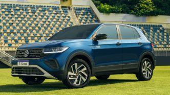 Volkswagen T-Cross Seleção azul estacionado em campo de futebol, com rodas de liga leve e design moderno em destaque