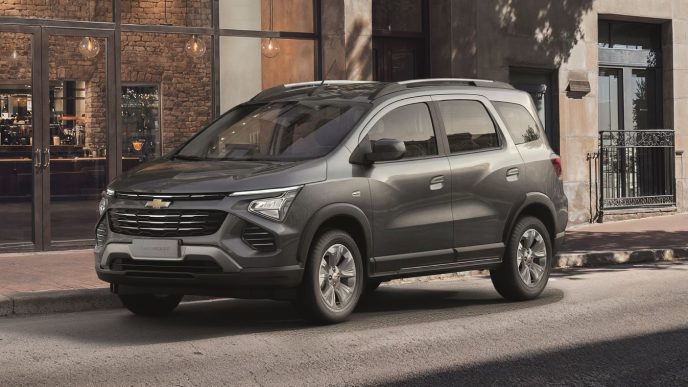 Chevrolet Spin 2027 na cor cinza estacionada em área urbana, destacando o novo design frontal, grade escurecida e rodas redesenhadas.
