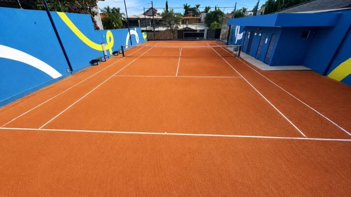 Quadra de tênis da nova unidade Fast Tennis no bairro Belvedere, em Belo Horizonte, com piso de saibro sintético, estrutura moderna e área preparada para aulas e treinos.