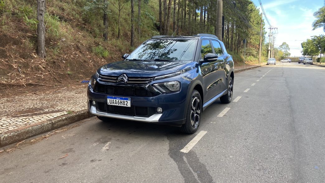 Citroën Aircross 7 XTR Turbo 200 AT 2026 azul estacionado em via urbana, visto de frente, destacando grade frontal, faróis em LED, rodas de liga leve e visual aventureiro.