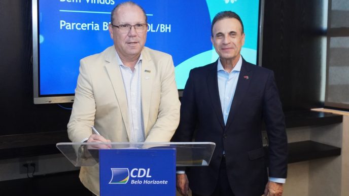 Dois representantes da CDL/BH e do BDMG posam durante formalização de parceria para oferta de crédito a micro e pequenas empresas.