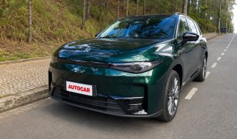 Leapmotor C10 REEV verde, visto de frente e em ângulo lateral, estacionado em uma rua arborizada durante teste do Balcão News.