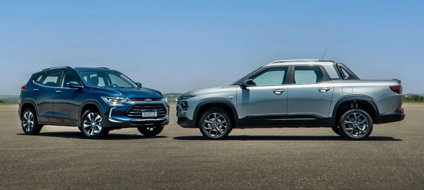 SUV azul e picape prata numa pista de aeródromo