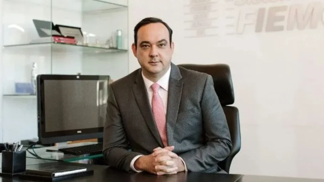 O presidente da Fiemg, Flávio Roscoe, de paletó e gravata, no seu gabinete de trabalho.