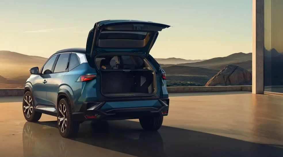 Renault Boreal 2025 estacionado com porta-malas aberto, revelando amplo espaço de carga, em cenário externo com luz natural suave.