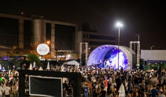 Grande público prestigia show noturno ao ar livre durante evento gastronômico da Churrascaria Porcão em Belo Horizonte, com palco iluminado e estrutura profissional ao fundo.