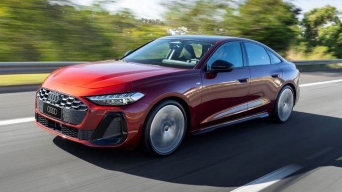Novo Audi A5 2025 em movimento, na cor vermelho granadina, exibindo design renovado, rodas esportivas e faróis full-LED em rodovia.