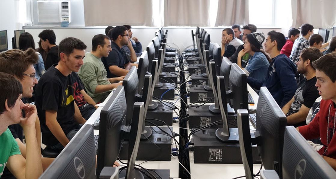 Turma de alunos em laboratório de informática durante aula prática em curso gratuito de capacitação profissional oferecido pelo Senac.