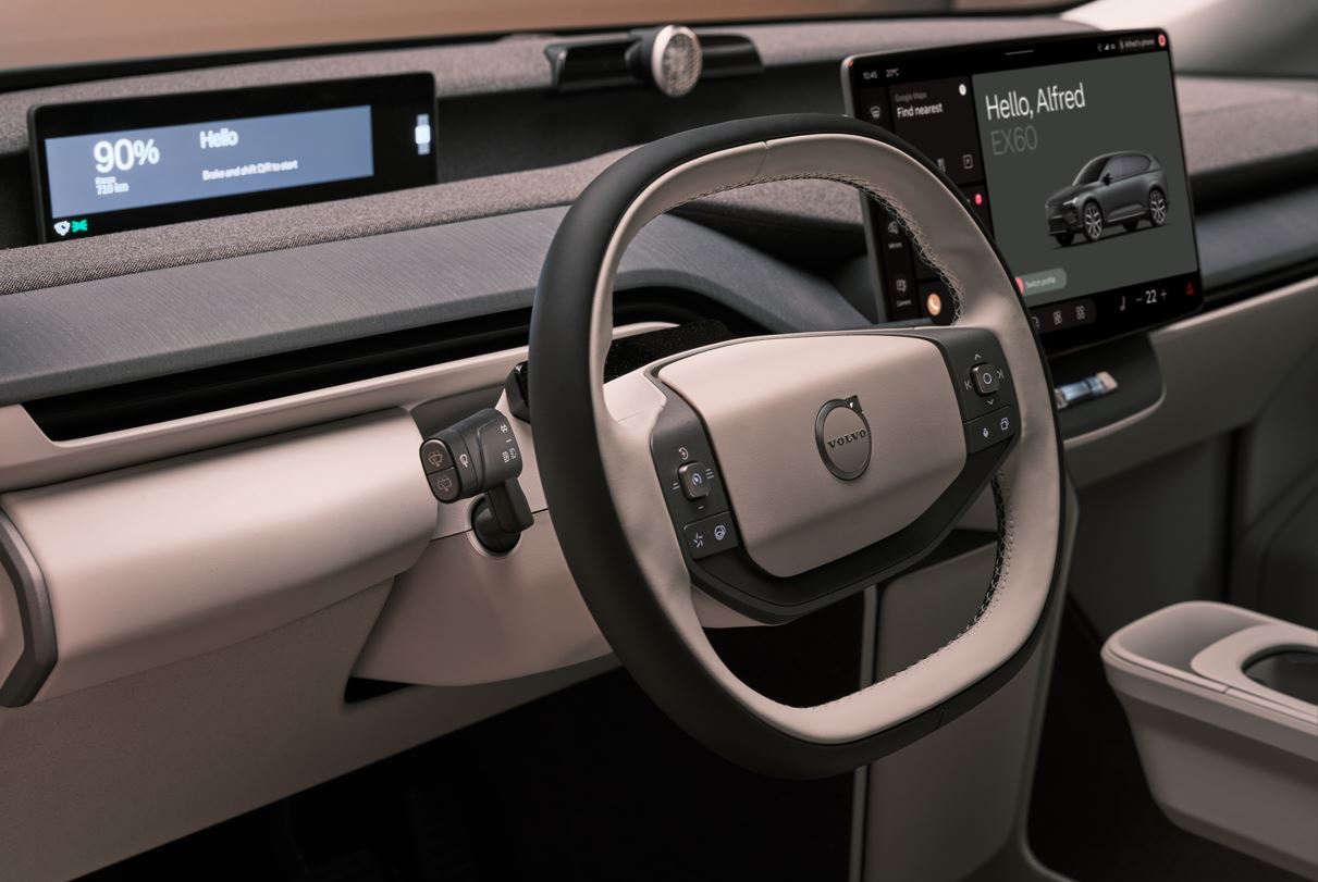 Detalhe do volante multifuncional do Volvo EX60, com acabamento premium, comandos integrados e painel digital ao fundo.