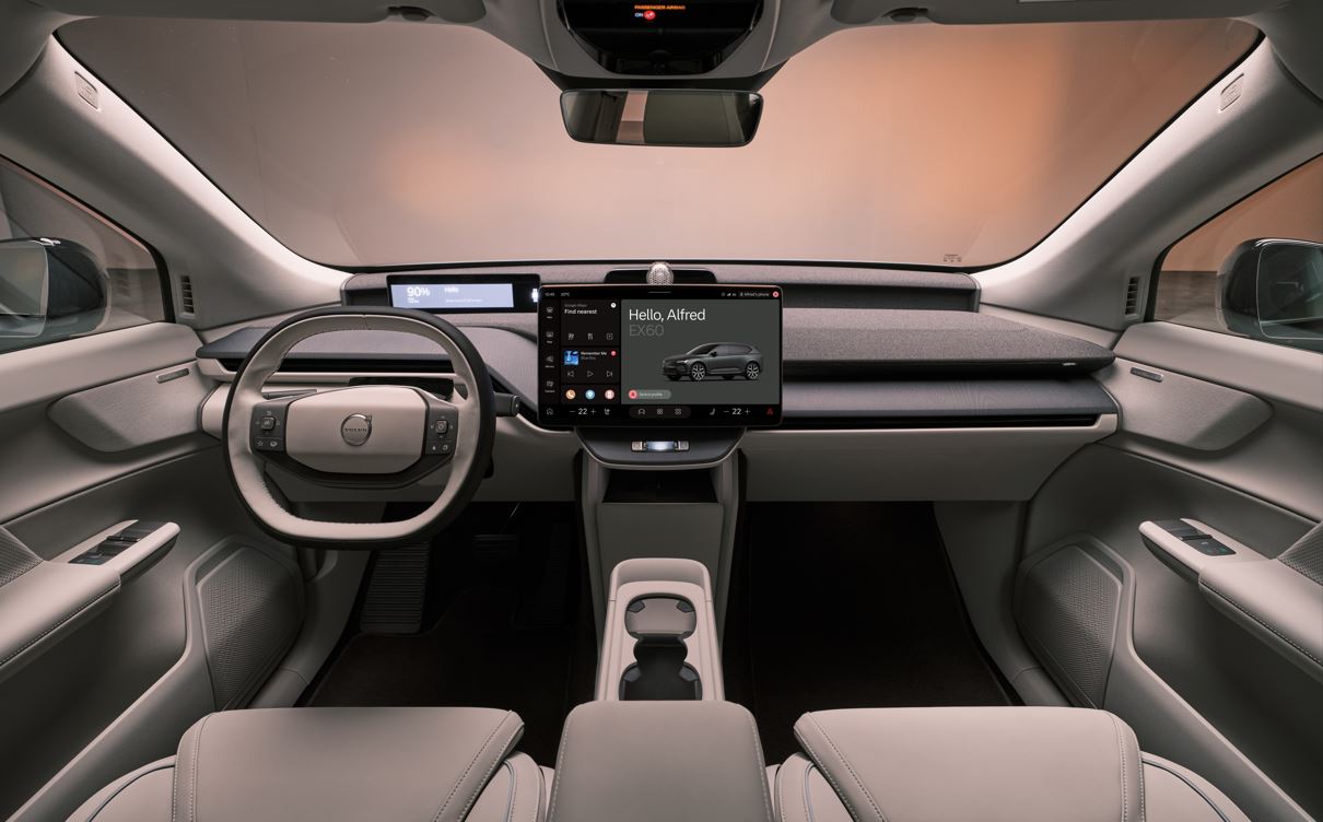 Interior do Volvo EX60 com acabamento minimalista, volante multifuncional, painel digital e central multimídia flutuante de alta resolução.