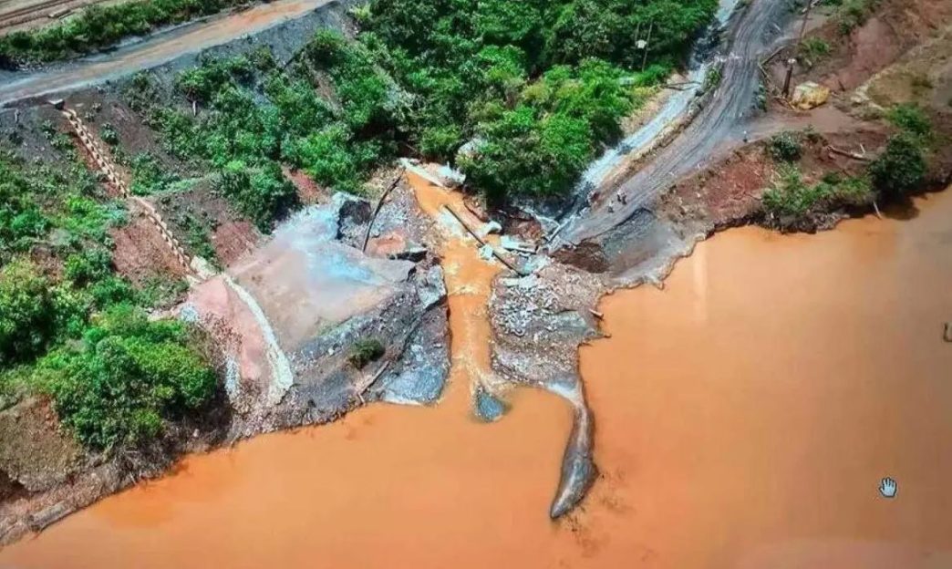 Imagem aérea mostra vazamento de sedimentos com água barrenta de área mineradora da Vale atingindo curso d’água em região florestal.