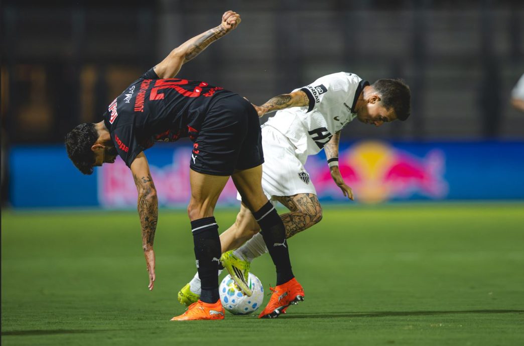 Jogadores do Atlético-MG e do RB Bragantino disputam intensamente a posse de bola durante partida do Campeonato Brasileiro, em Bragança Paulista.