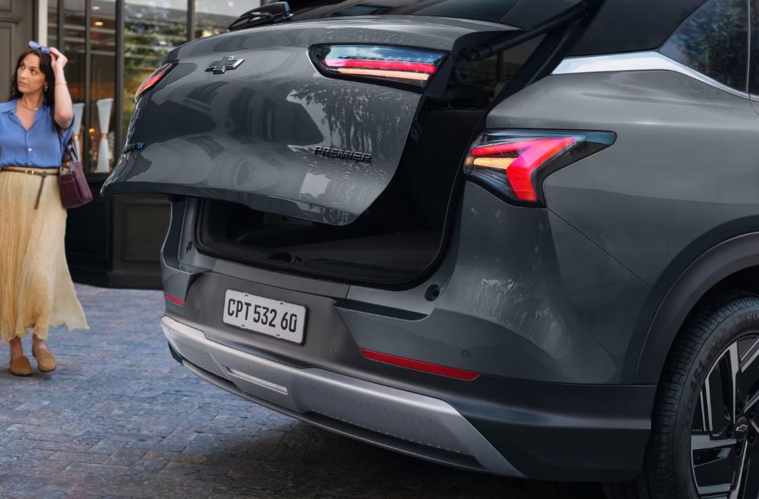 Porta-malas do Chevrolet Captiva EV com abertura elétrica acionada, destacando lanternas em LED e amplo espaço interno do SUV elétrico.