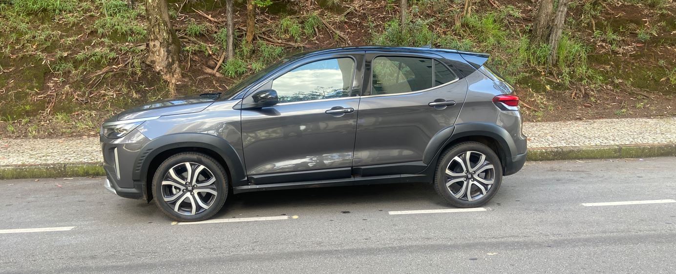 Fiat Pulse Impetus Hybrid 2026 em perfil lateral, na cor cinza, com rodas de liga leve aro 18, estacionado em rua arborizada de Belo Horizonte.