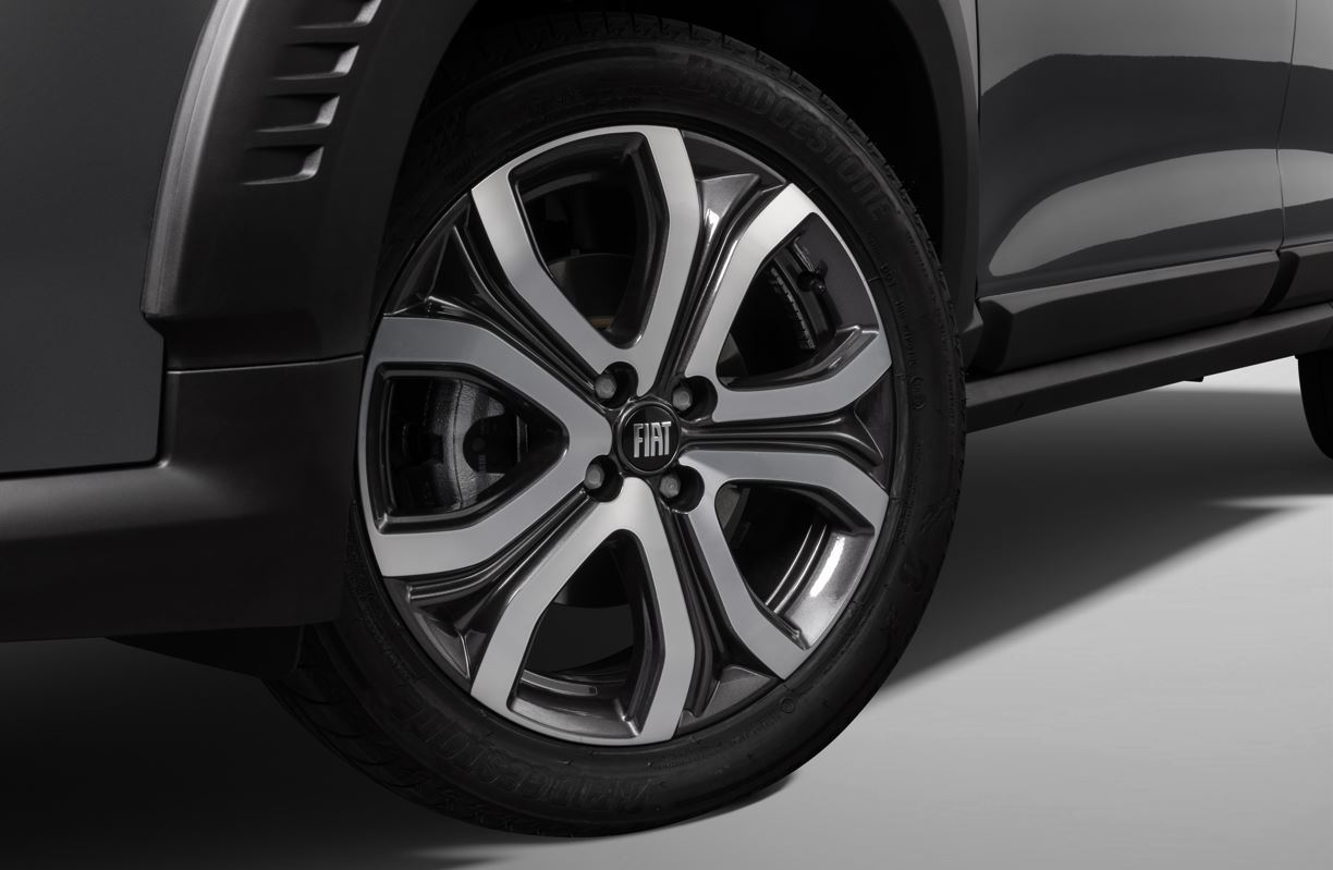 Roda de liga leve aro 18 do Fiat Pulse Impetus Hybrid 2026 com acabamento diamantado e detalhes escurecidos, exibindo o logotipo FIAT ao centro.