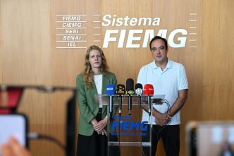Dirigentes da FIEMG e da Codemge em coletiva à imprensa, diante de púlpito com microfones, durante anúncio da aquisição do Expominas Juiz de Fora, em Belo Horizonte.