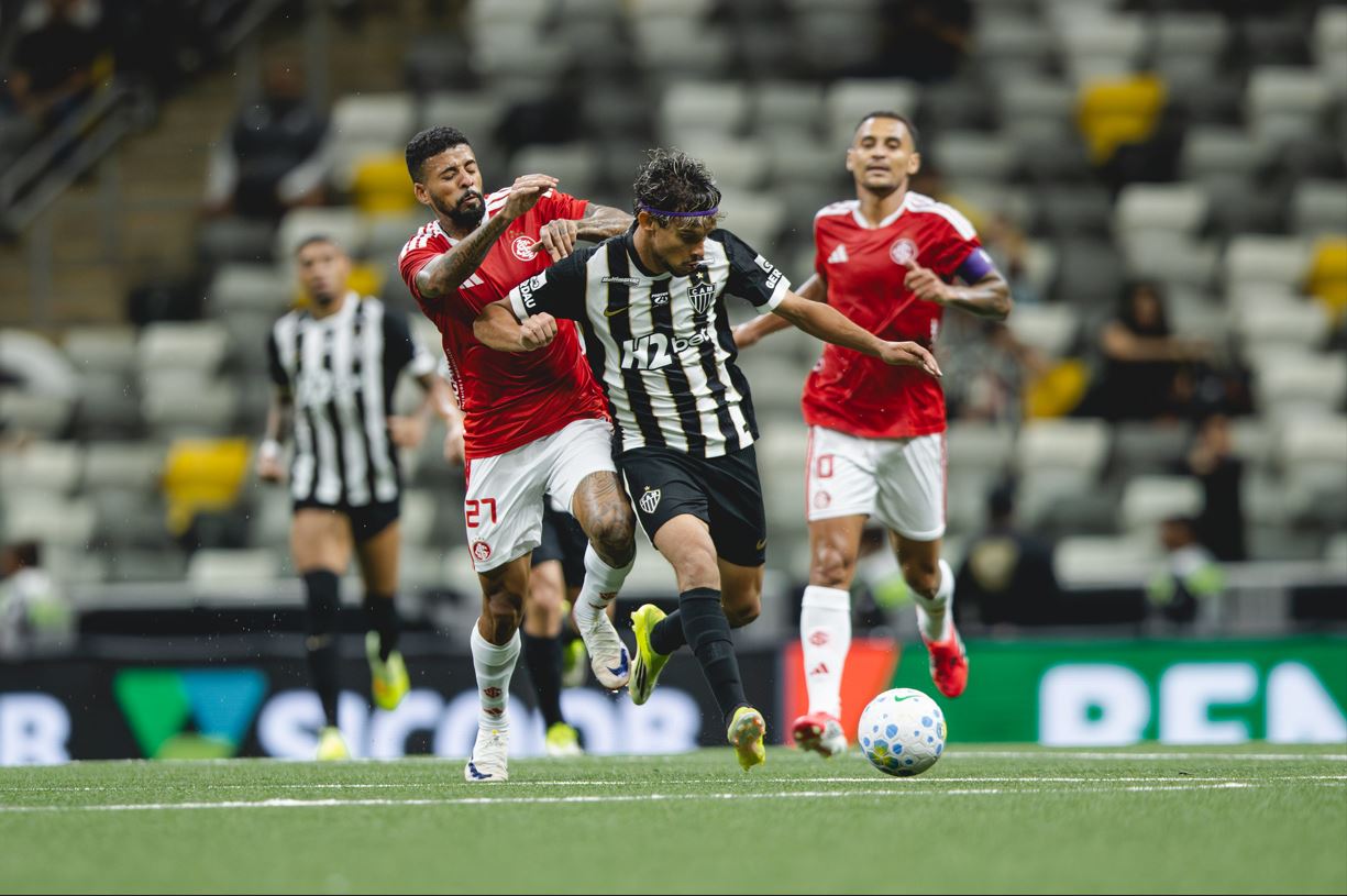 Jogador do Atlético Mineiro disputa a bola com atleta do Internacional durante partida do Brasileirão 2026 na Arena MRV, em Belo Horizonte.
