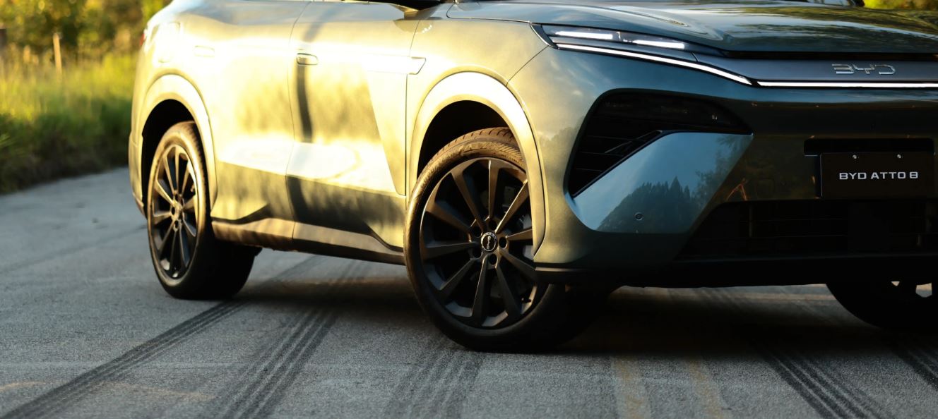 Detalhe lateral do BYD Atto 8 com rodas de liga leve, design aerodinâmico e acabamento moderno em SUV híbrido plug-in