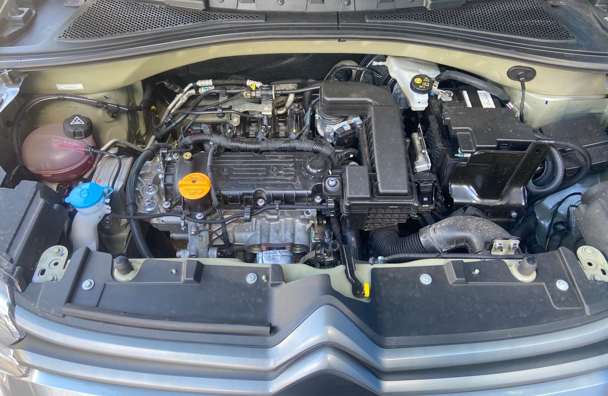 Compartimento do motor do Citroën C3 XTR 1.0 2026 aberto, destacando o conjunto Firefly 1.0, organização dos componentes mecânicos e acesso aos principais reservatórios para manutenção.