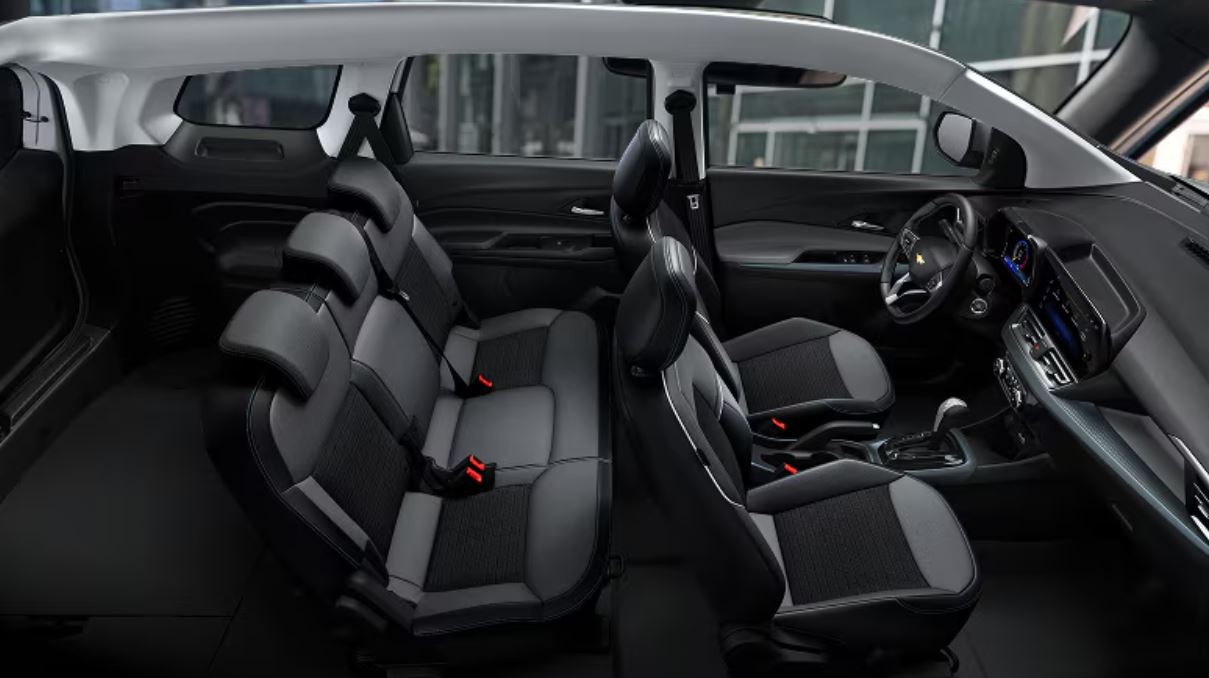 Interior da Chevrolet Spin 2027 com configuração para sete lugares, destacando amplo espaço interno, bancos confortáveis e painel multimídia.