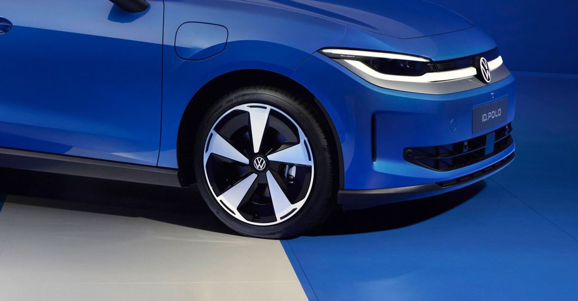 Detalhe da roda aerodinâmica e da dianteira do Volkswagen ID. Polo elétrico azul evidencia design moderno e acabamento futurista.