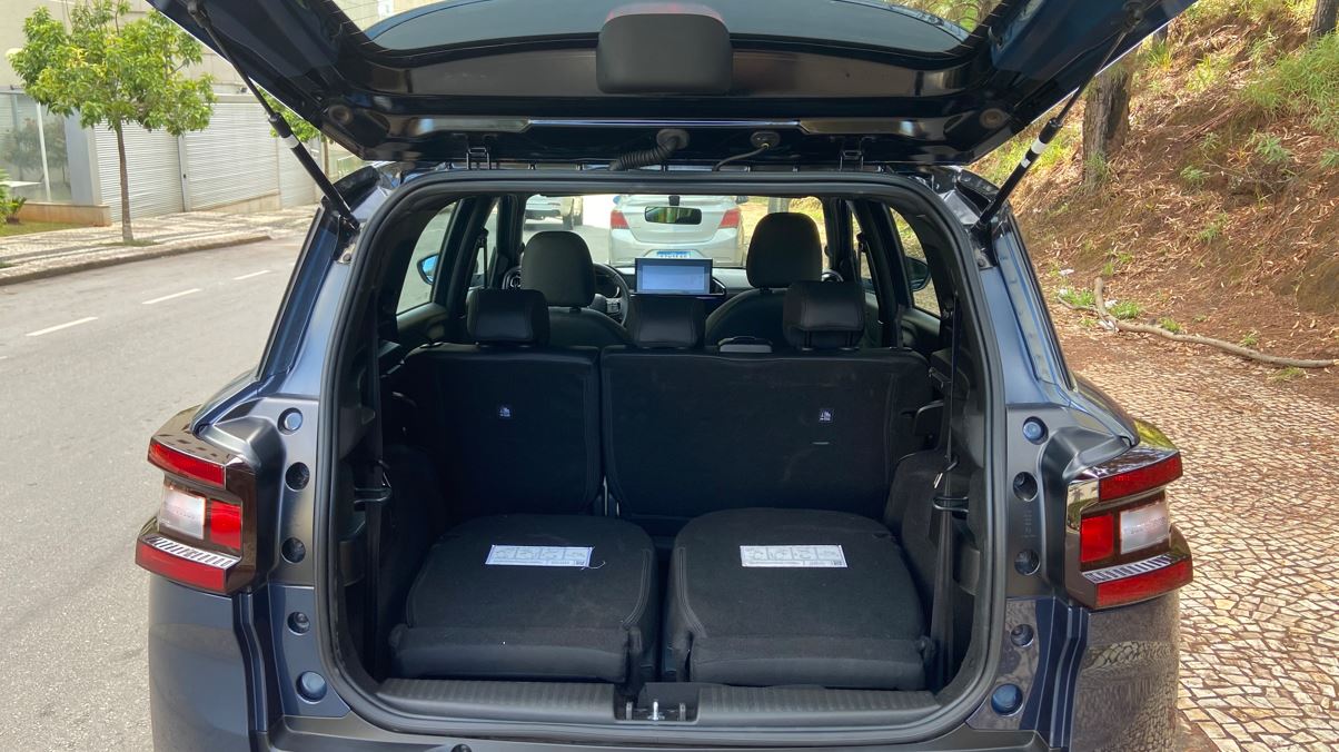 Porta-malas do Citroën Aircross XTR 7 2026 aberto, com os bancos da terceira fileira rebatidos e visão da cabine em configuração familiar.