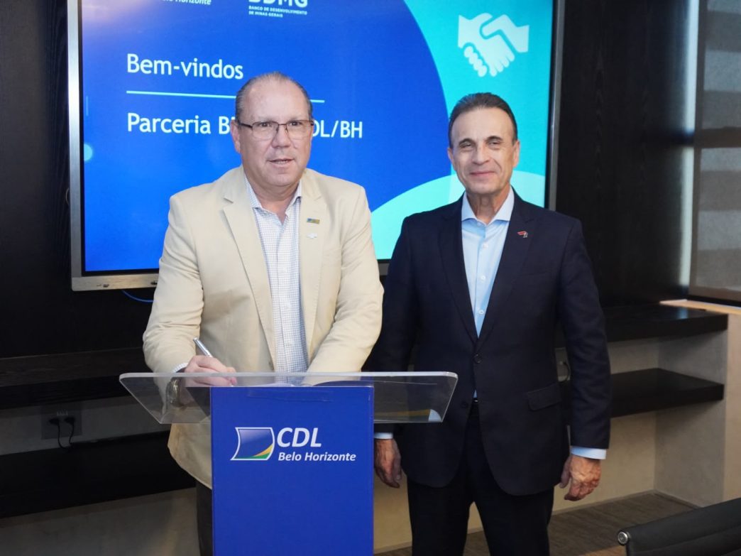 Dois representantes da CDL/BH e do BDMG posam durante formalização de parceria para oferta de crédito a micro e pequenas empresas.