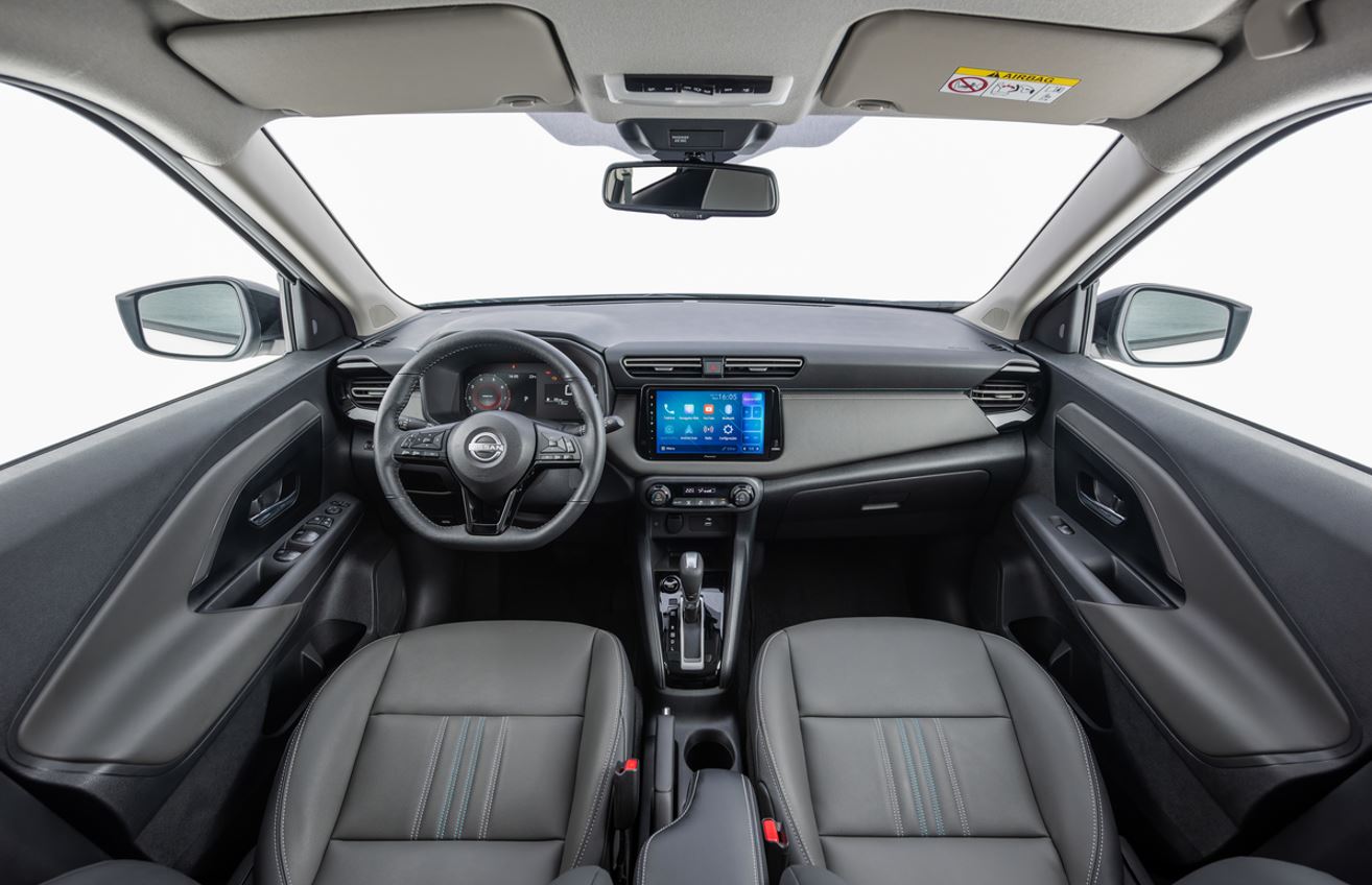 Interior do Nissan Kait visto a partir dos bancos dianteiros, com volante multifuncional, painel digital, central multimídia, câmbio automático CVT e cabine ampla.