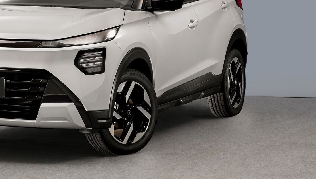 Nissan Kait ganha versões Sense e Advance no Brasil 5 Detalhe lateral do Nissan Kait branco, com faróis em LED, molduras pretas nos para-lamas, pneus 205/55 R17 e rodas de liga leve com acabamento diamantado.