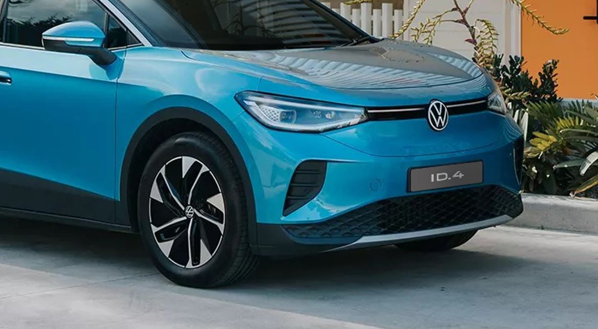 Detalhe frontal do Volkswagen ID.4 azul, com destaque para faróis, logotipo VW, para-choque dianteiro e roda do SUV elétrico.
