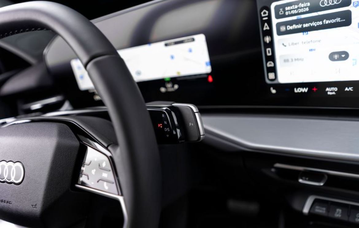Detalhe do interior do novo Audi Q3 mostra o volante multifuncional, o seletor eletrônico de marchas na coluna de direção e as telas digitais do painel e da central multimídia.