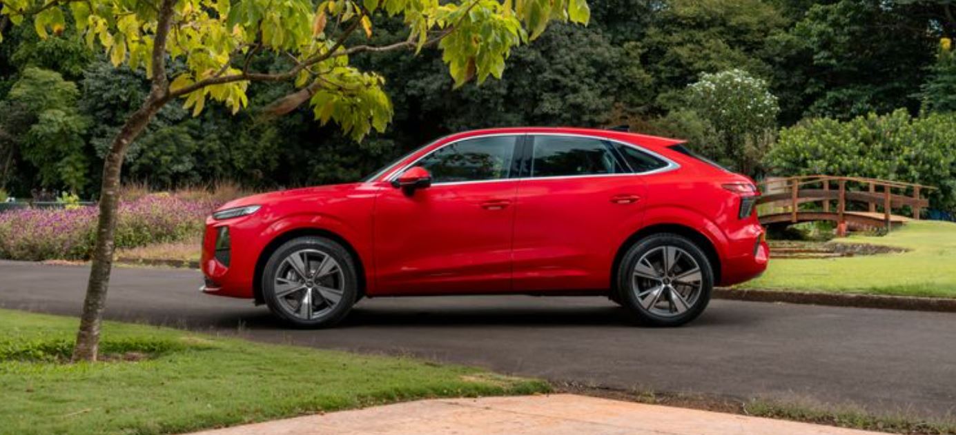 Perfil lateral do novo Audi Q3 Sportback vermelho evidencia a silhueta esportiva inspirada em cupês, linhas fluidas e rodas de liga leve de 19 polegadas.