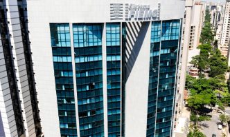 Fachada da sede do Sistema FIEMG, em Belo Horizonte, com edifícios e área arborizada ao redor.