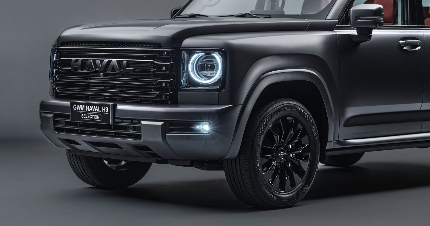Detalhe frontal do Haval H9 Selection com grade preta brilhante, faróis de LED e roda de liga leve aro 19.