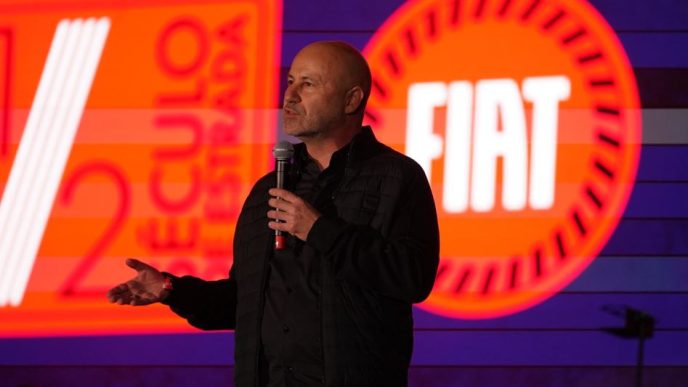 Herlander Zola, presidente da Stellantis para a América do Sul, fala ao microfone diante de um painel da Fiat.