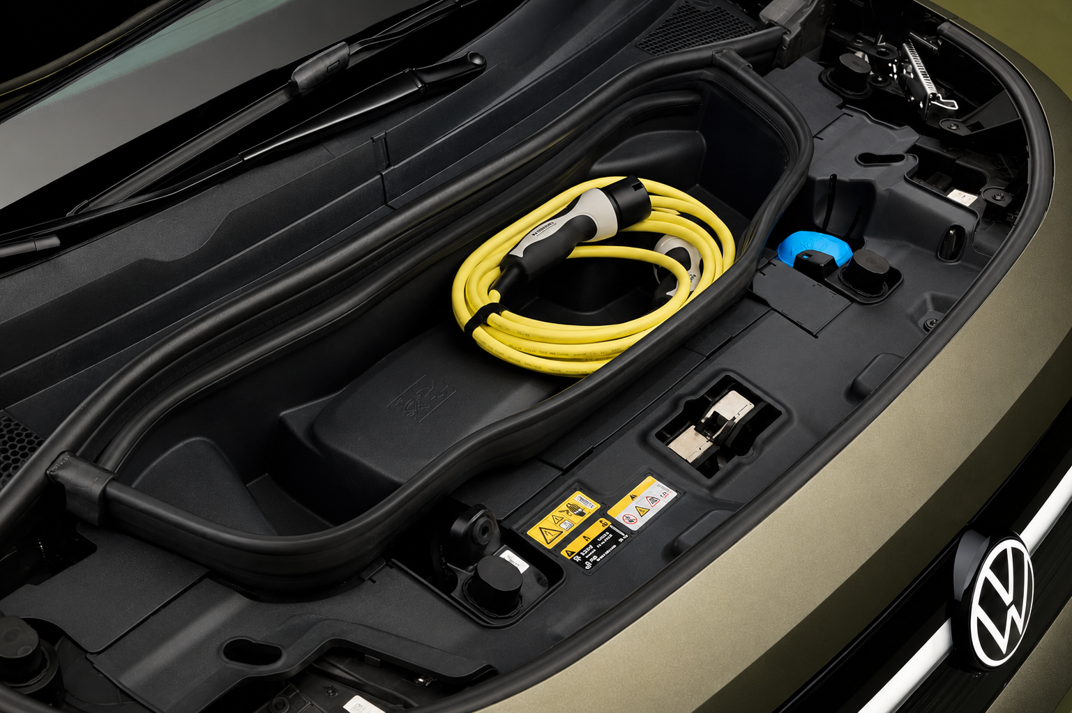 Compartimento dianteiro do Volkswagen ID. Cross com cabo de recarga amarelo acomodado no frunk de 25 litros.