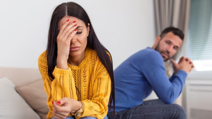 Casal discutindo a relação – casal sentados em uma cama tristes.