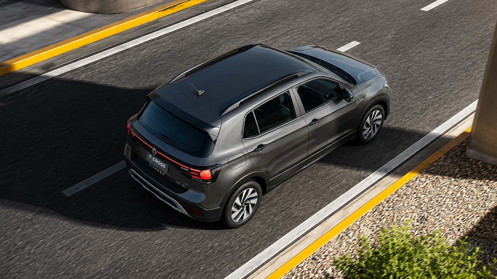 Volkswagen T-Cross 2027 cinza em movimento, visto de cima, com teto panorâmico e lanternas traseiras interligadas em destaque.