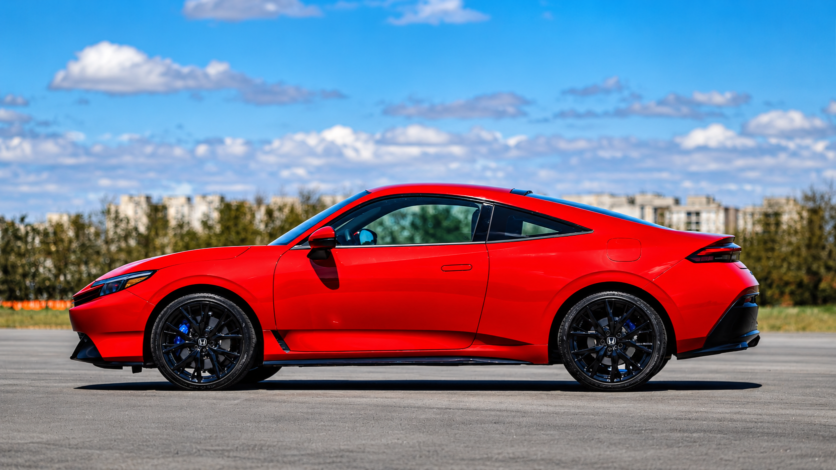 Honda Prelude 2026 vermelho visto de perfil, destacando a silhueta baixa de cupê, teto inclinado, rodas pretas de 19 polegadas e pinças de freio azuis.