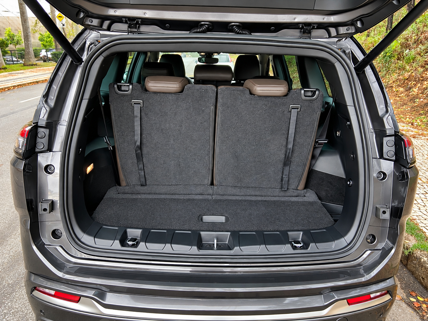 Porta-malas do Jeep Commander 2027 com a terceira fileira de bancos levantada, mostrando o espaço disponível atrás dos sete lugares.