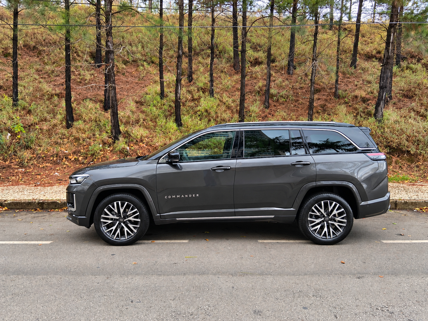 Vista lateral do Jeep Commander 2027, com carroceria alongada, rodas de liga leve, caixas de roda marcadas e acabamento cromado nas janelas.