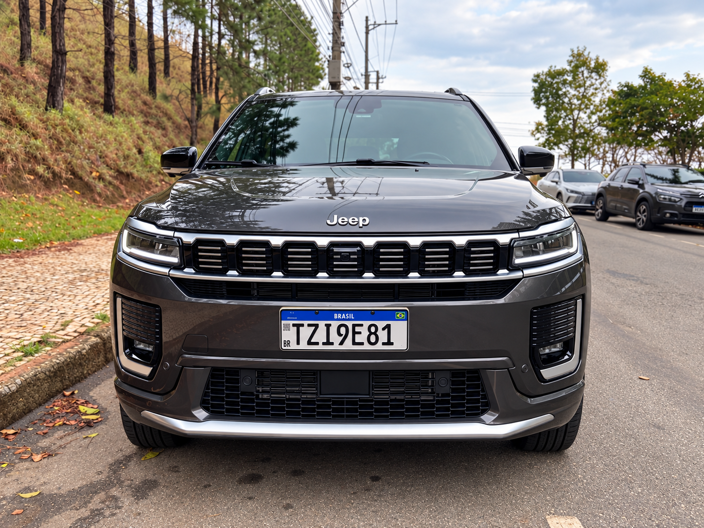 Vista frontal do Jeep Commander 2027, com destaque para a grade de sete fendas, faróis em LED e acabamento cromado.