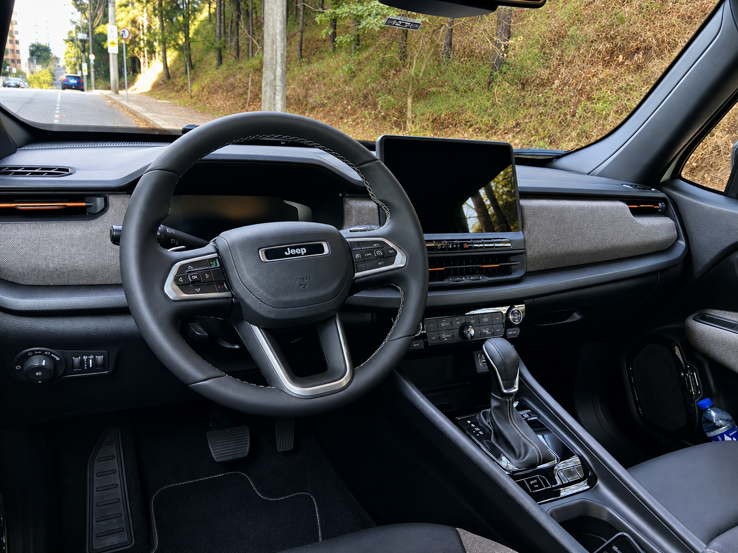 Interior do Jeep Renegade Sahara MHEV com volante multifuncional, painel de instrumentos digital, central multimídia de 10,1 polegadas e câmbio automático.