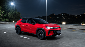 Volkswagen Tera 200 TSI vermelho em movimento durante a noite, com faróis de LED acesos, rodas pretas e carroceria de SUV compacto.